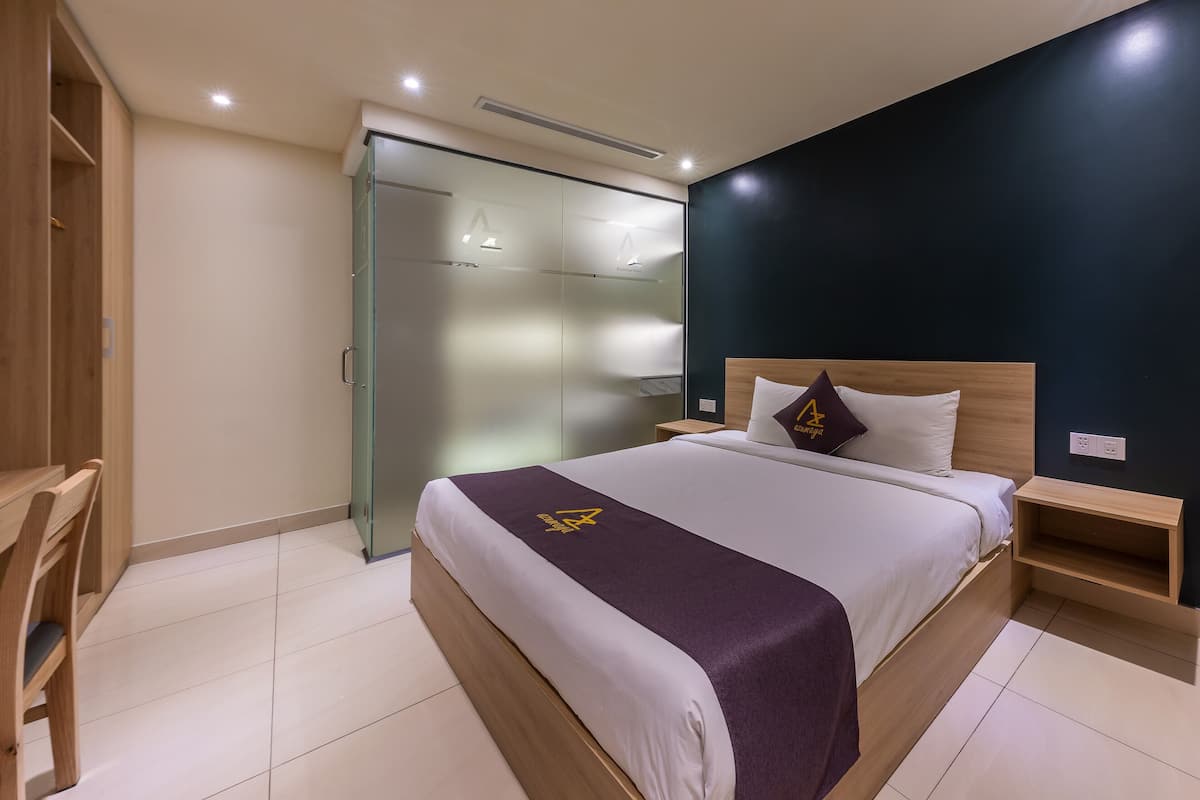 Ein Hotelzimmer mit Bett, Nachttisch und Kleiderschrank.