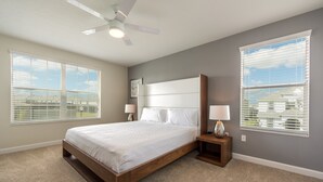 A bedroom with a large bed, two bedside tables, a ceiling fan, and large windows with blinds. - Champions Gate Home 2 U- Thor - Cg1561 (Davenport)