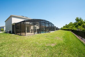 A modern house with a large covered patio area and a well-maintained lawn.