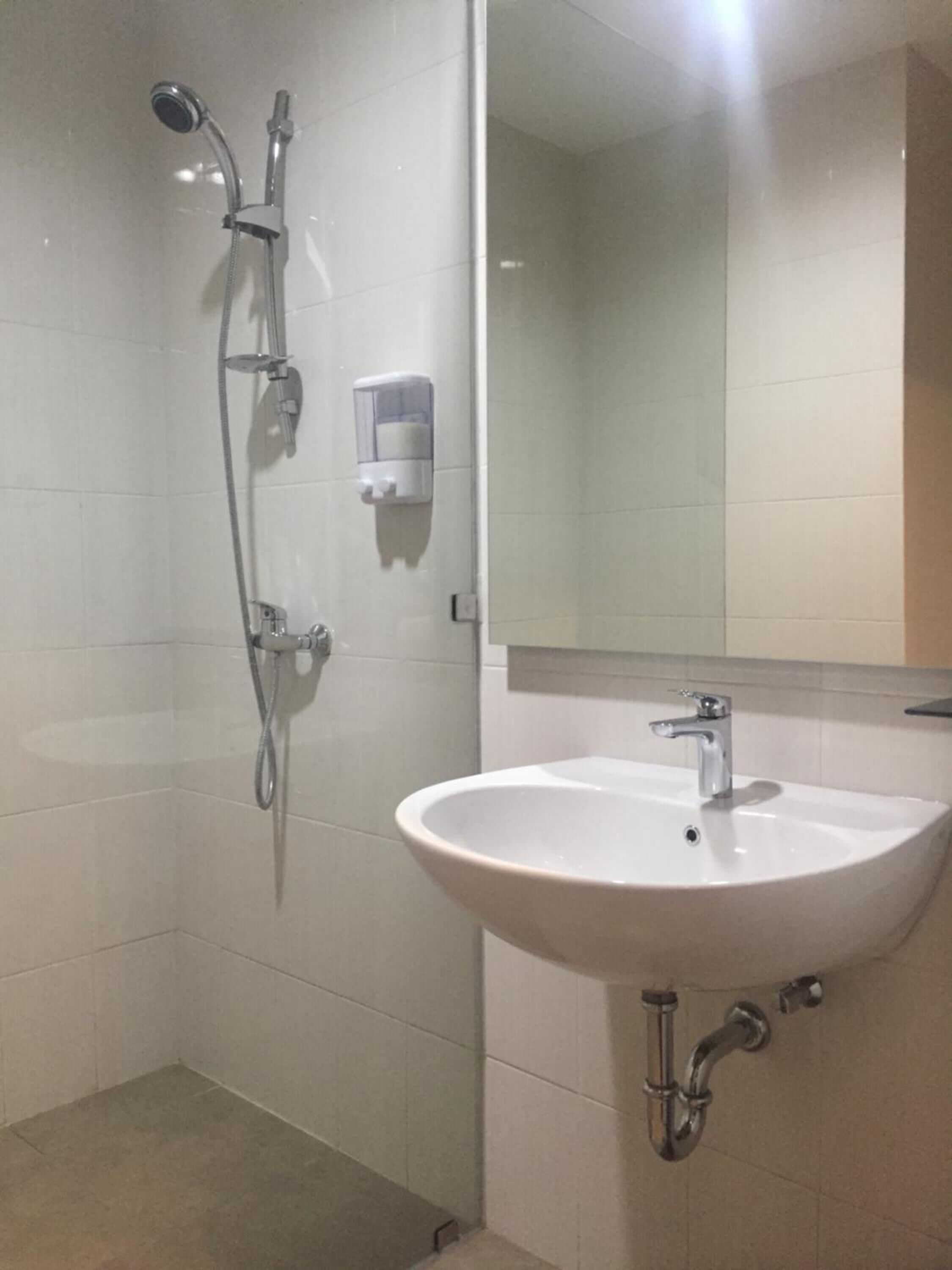 A bathroom with a shower, a sink, and a mirror.