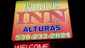 A neon sign for 'MODOC INN' with 'ALTURAS' and a phone number. - Modoc Inn (Alturas)