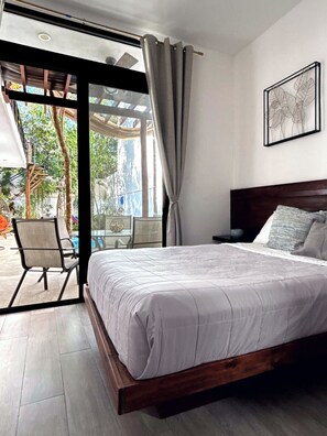 A bedroom with a bed, a chair, a table, and a view of the outdoors. - Near the Beach ✦  Relaxing 5 BRD Villa  with  Rooftop & Private Pool ✦Sleeps 10. (Tulum)