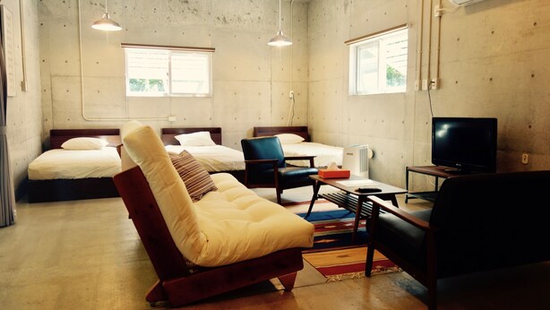 A room with a bed, a sofa, a TV, and a desk. - Retya (Ishigaki)