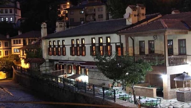 A building with multiple windows and a balcony, surrounded by other buildings.