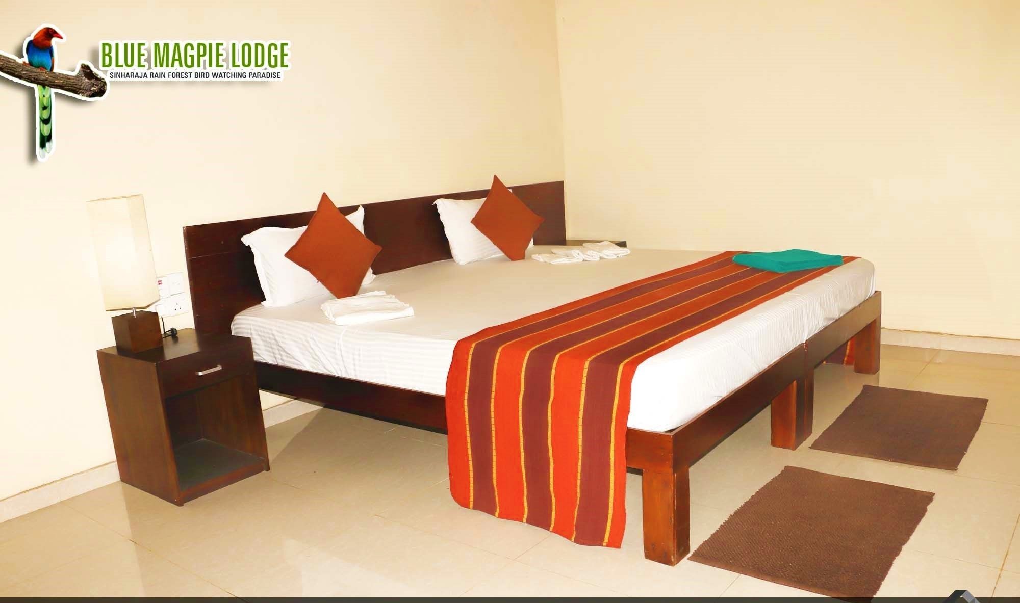 A hotel room with a large bed, wooden headboard, and a nightstand with a lamp.