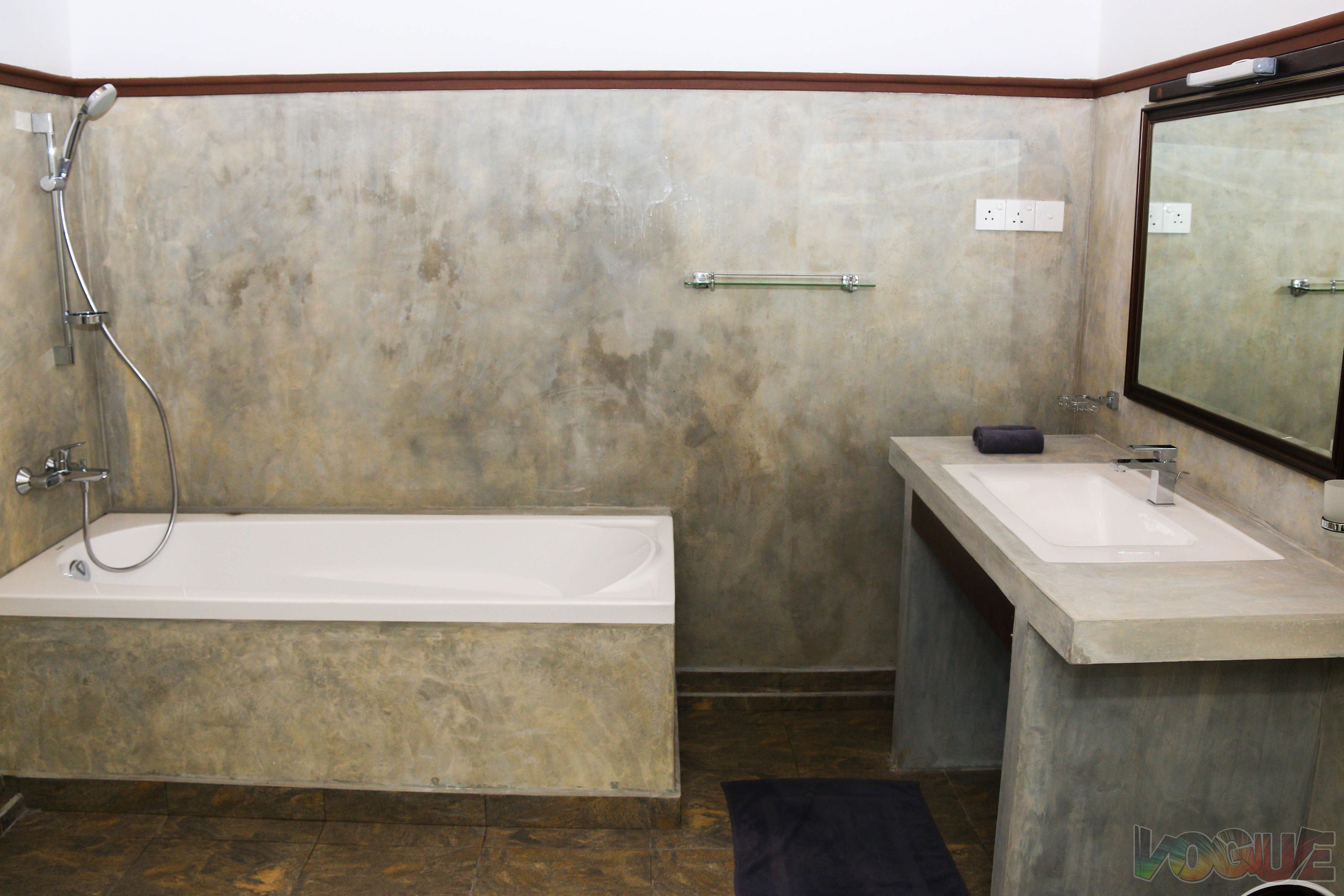 A bathroom with a bathtub, a sink, and a mirror.