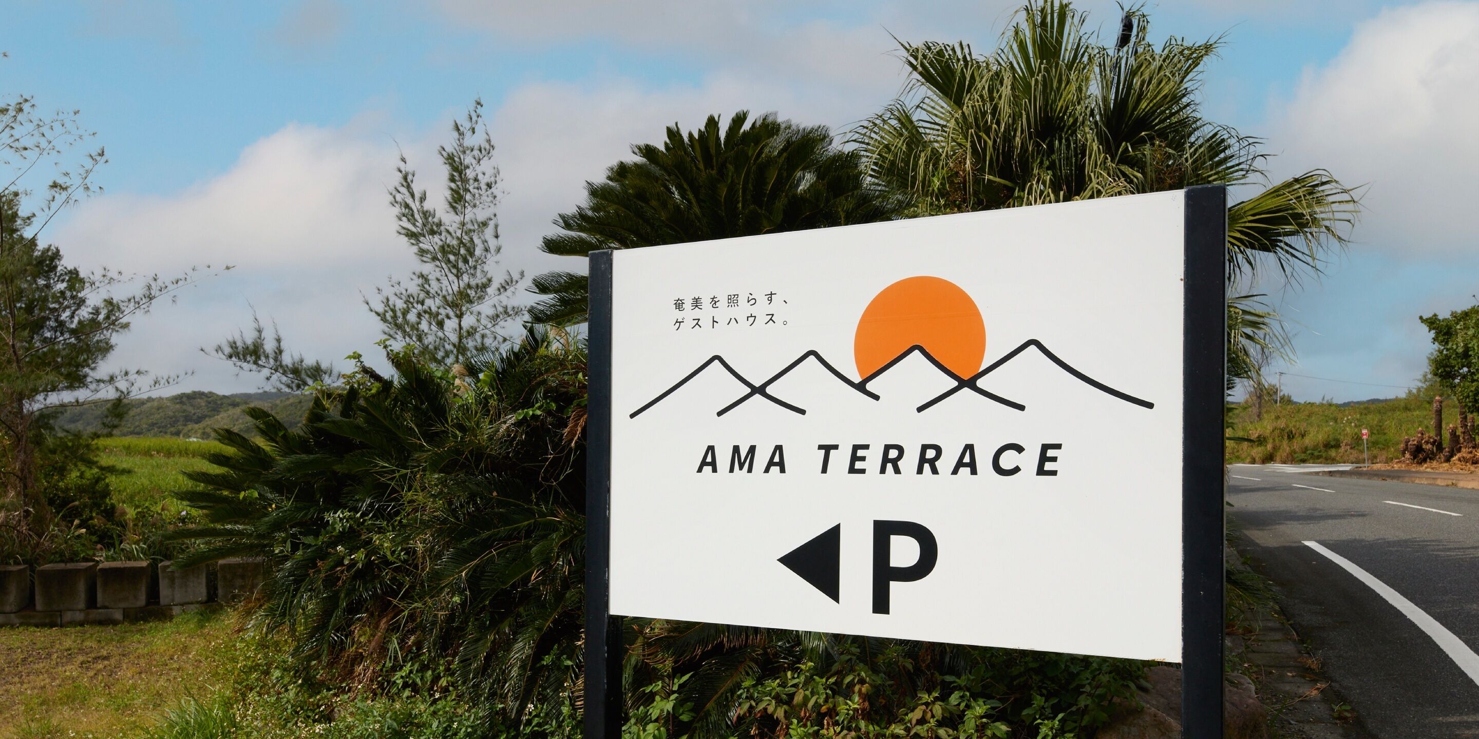 Une enseigne pour Ama Terrace, avec un motif représentant une montagne et un soleil, indiquant un endroit offrant un paysage magnifique.