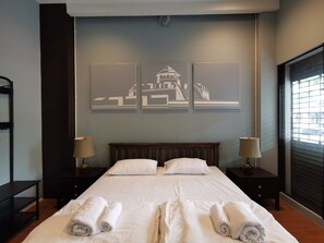 A hotel room with a large bed, two bedside tables, and three wall-mounted artwork pieces. - A Bangkok Journey Hostel (Bangkok)