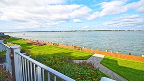 A waterfront promenade with a wooden deck, benches, and a grassy area with flowers. - Harbour Island 102M 2 Bedroom Condo by RedAwning (Ocean City)