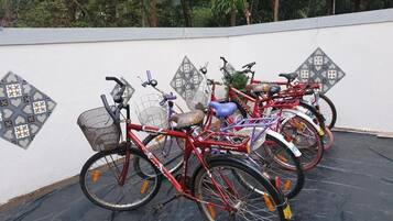 Des vélos sont garés contre un mur orné d’un motif géométrique.