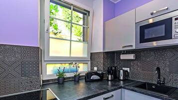 Eine moderne Küche mit Fenster, integriertem Mikrowellenherd und Spüle.