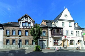 Un hotel europeo tradicional con una fachada clásica, una entrada central y un letrero que indica que es un hotel.