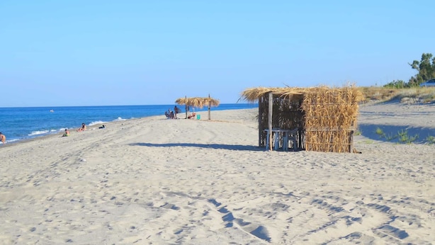 A beach with a thatched hut and a sandy path leading to the sea. - Elegant Holiday Home, in the Village (Badolato)