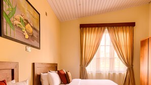 A hotel room with two beds, wooden headboards, a painting on the wall, a window with curtains, and a wooden wardrobe. - Spice Ella (Ella)