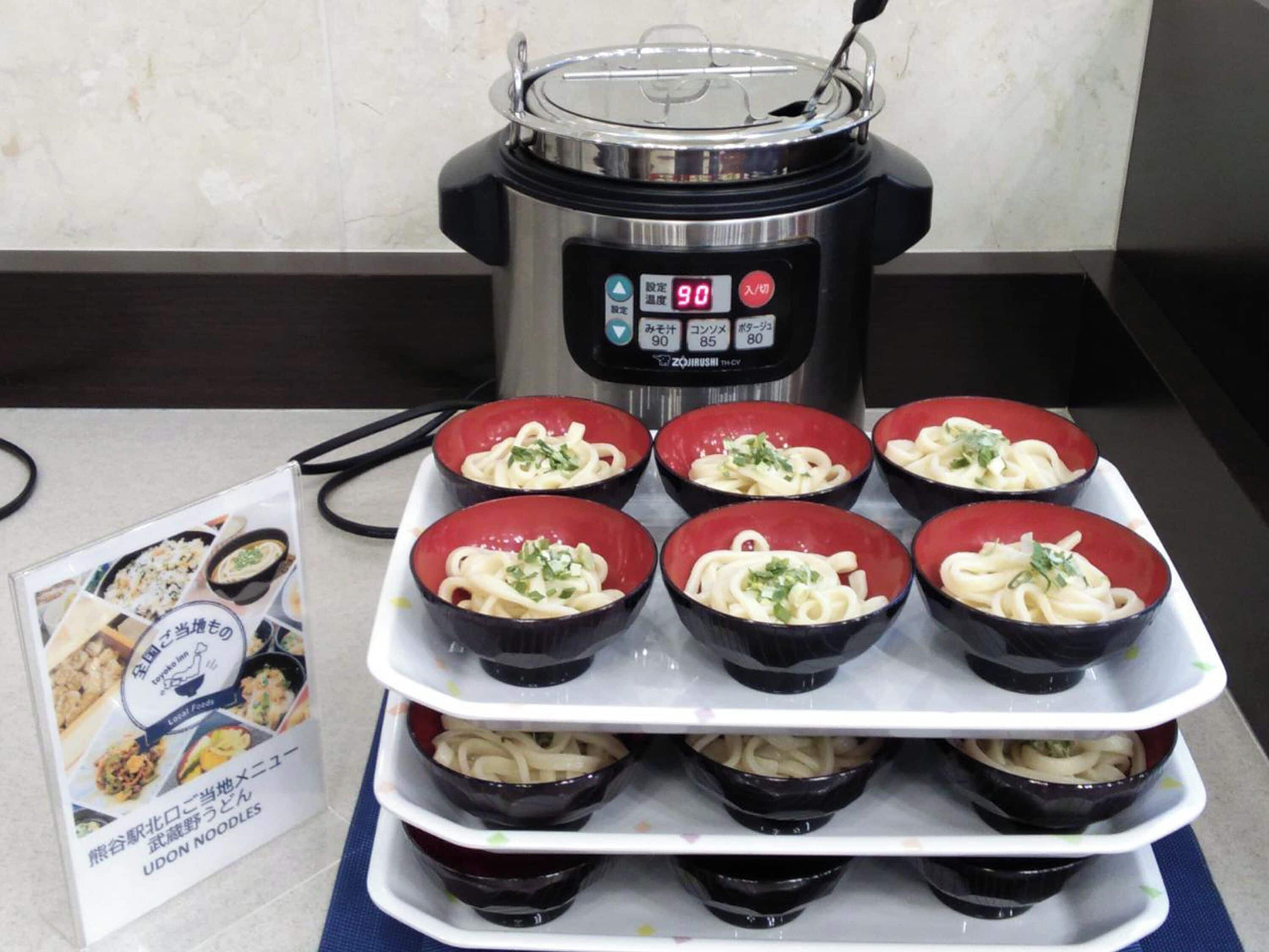Una cocina con una olla a presión y tazones de fideos udon.