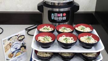 Una cocina con una olla a presión y tazones de fideos udon.