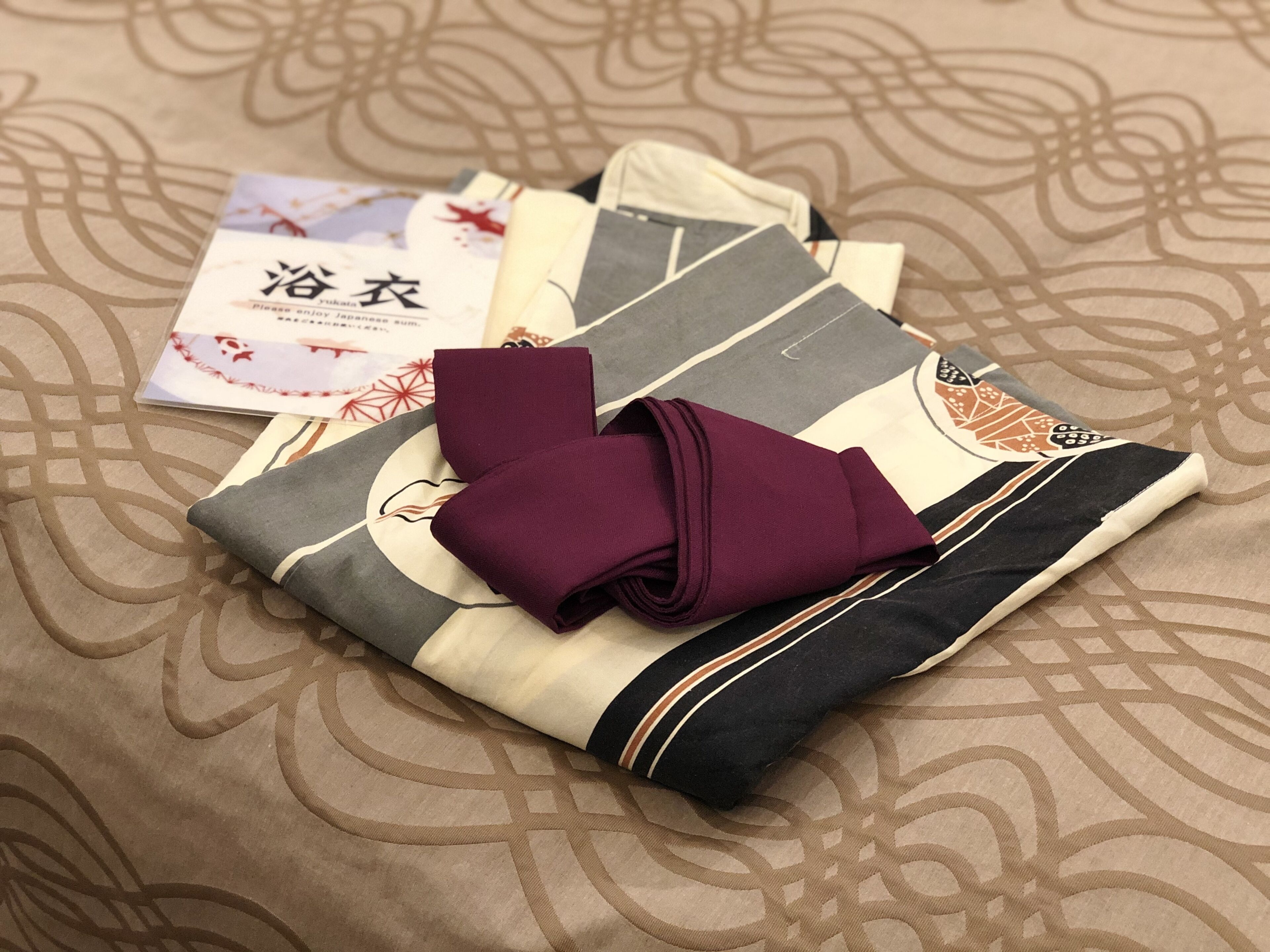 A neatly folded garment with a patterned fabric and a folded piece of paper with text.