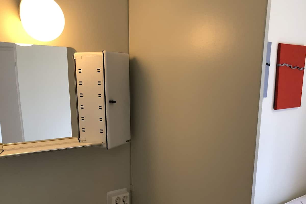 Ein Badezimmer mit einem weißen Waschbecken, einem Spiegel und einem Schrank mit Beleuchtung darüber.