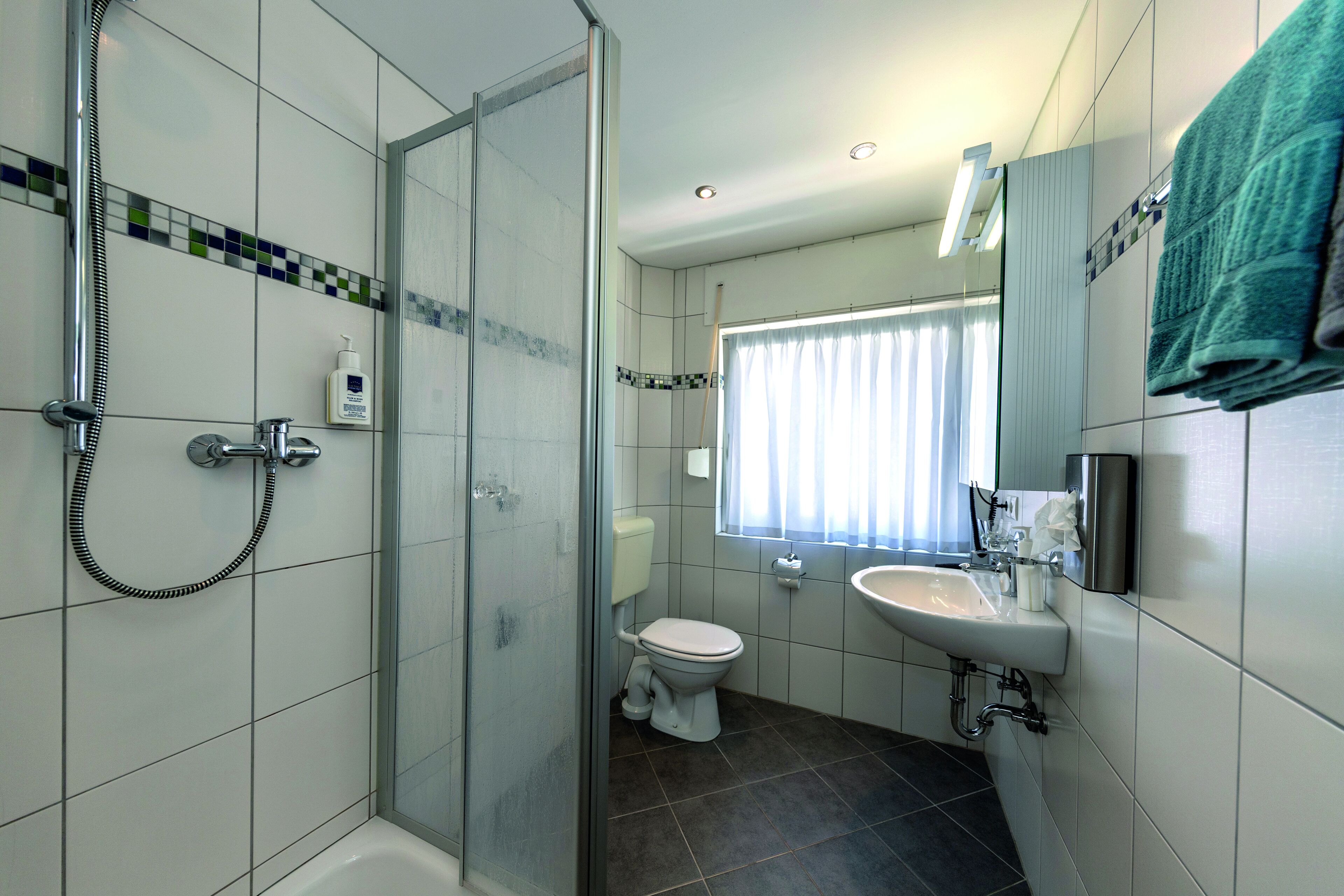Ein modernes Badezimmer mit Dusche, Toilette und Waschbecken.