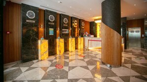 A hotel lobby with marble reception counters, clocks, and a modern design. - Theatrum Hotel Baku (Baku)