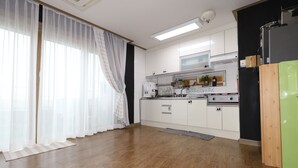 A modern kitchen with white cabinets, a stainless steel stove, and a green refrigerator. - Gangneung Ocean Marina Pension - Hostel (Gangneung)