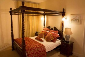 A four-poster bed with a canopy, a bedside table, a lamp, and a framed picture on the wall. - Courtmacsherry hotel (Courtmacsherry)