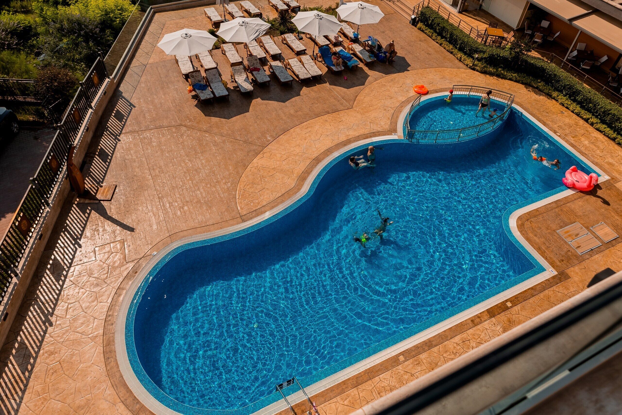 Una piscina al aire libre de temporada, sombrillas