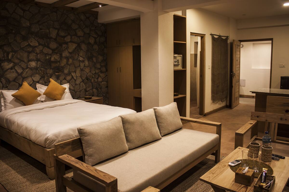 Un dormitorio con cama, muebles de madera y pared de piedra.