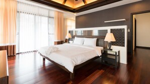 A modern hotel room with a large bed, wooden flooring, a ceiling fan, and a nightstand with a lamp. - Pool Villa Pattaya by Passionata (Pattaya)