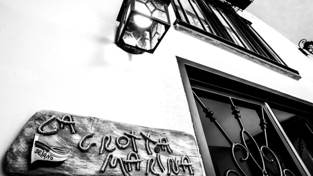 A building with a sign reading "CROTTI MARE" and a lantern above the entrance.