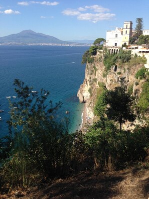 A coastal view with a building on a cliff overlooking the sea. - B&B La Grotta Marina (Vico Equense)