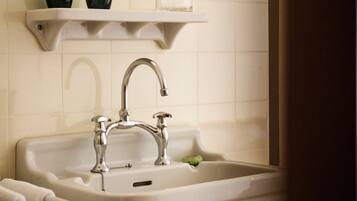 A bathroom sink with a chrome faucet, a mirror above it, and a towel rack to the left.