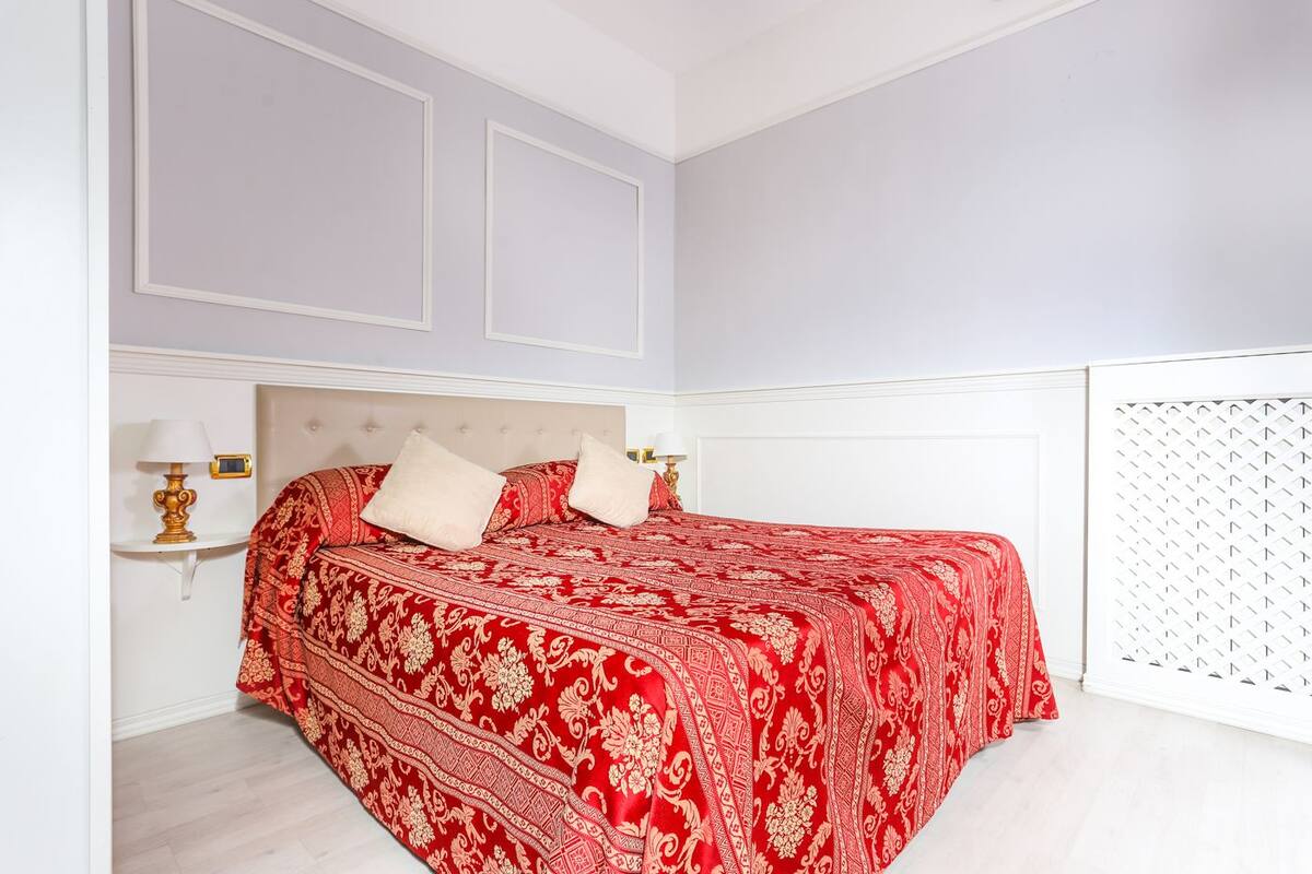 Ein Schlafzimmer mit einem Bett, zwei Nachttischen und einem weißen Kopfteil.