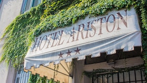 Une enseigne d’hôtel avec du lierre grimpant sur le mur.