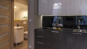A modern kitchen with a built-in stove, a sink, and a countertop. - Apartamenty 2M (Czestochowa)