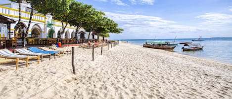 On the beach, white sand, sun-loungers, beach towels