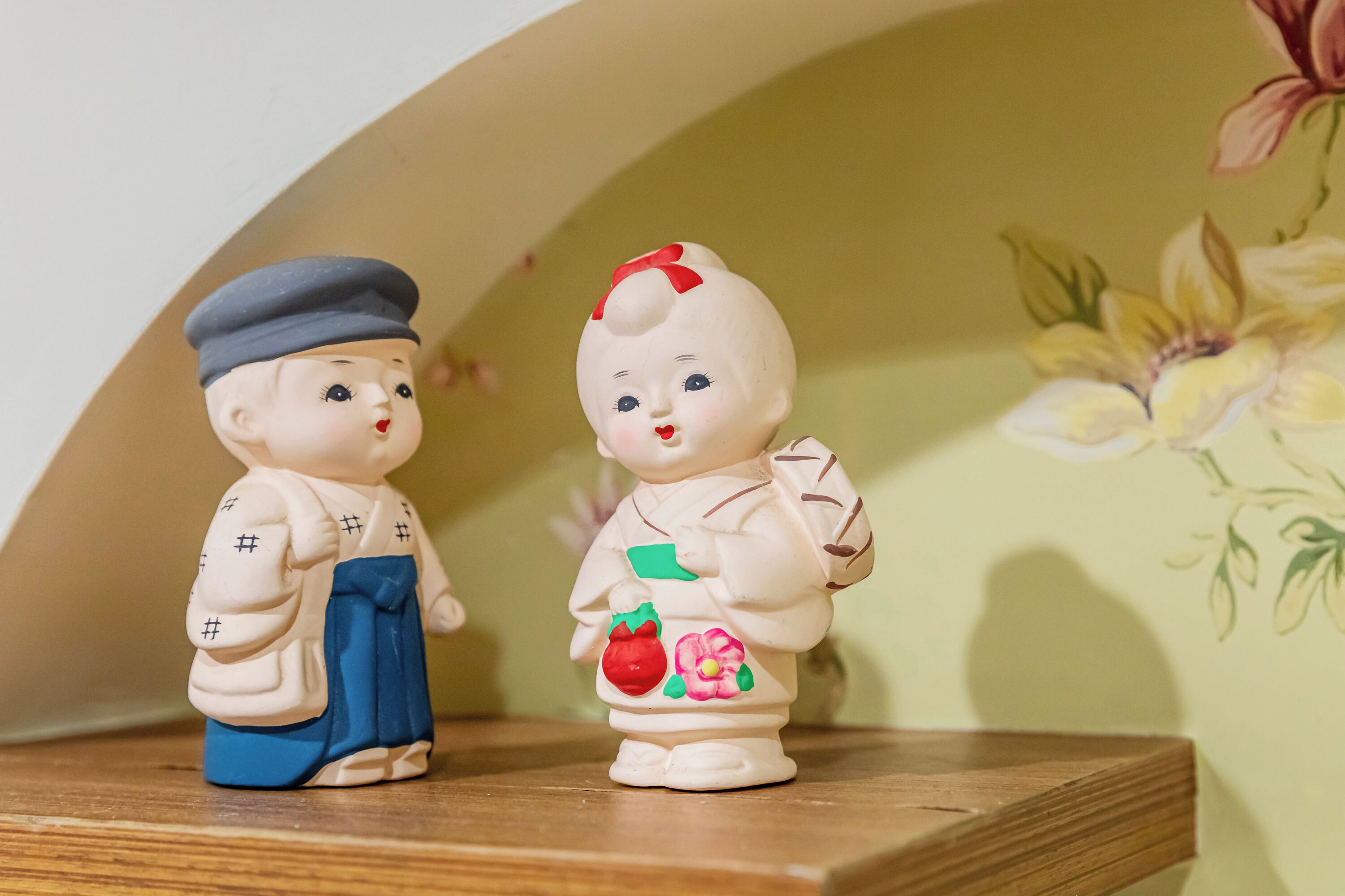 Dos figuritas de cerámica en una estantería.