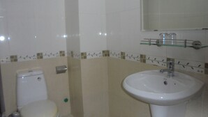Une salle de bain avec des toilettes, un lavabo et un miroir.