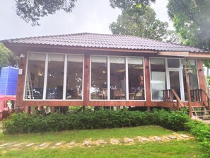 A wooden building with large windows, a tiled roof, and a staircase leading to a balcony. - Ariya Resort (Koh Rong)
