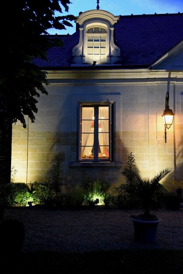 A stone building with a window and a wall-mounted light fixture. - Le Gaimont (Vouvray)