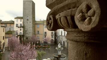 A stone architectural detail with a fountain in the background.