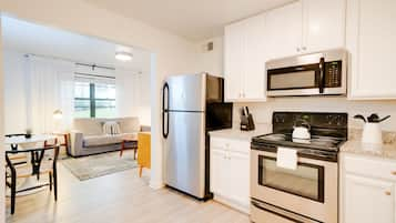 Departamento, vista al patio | Cocineta privada | Refrigerador, microondas, horno y parrilla de estufa 