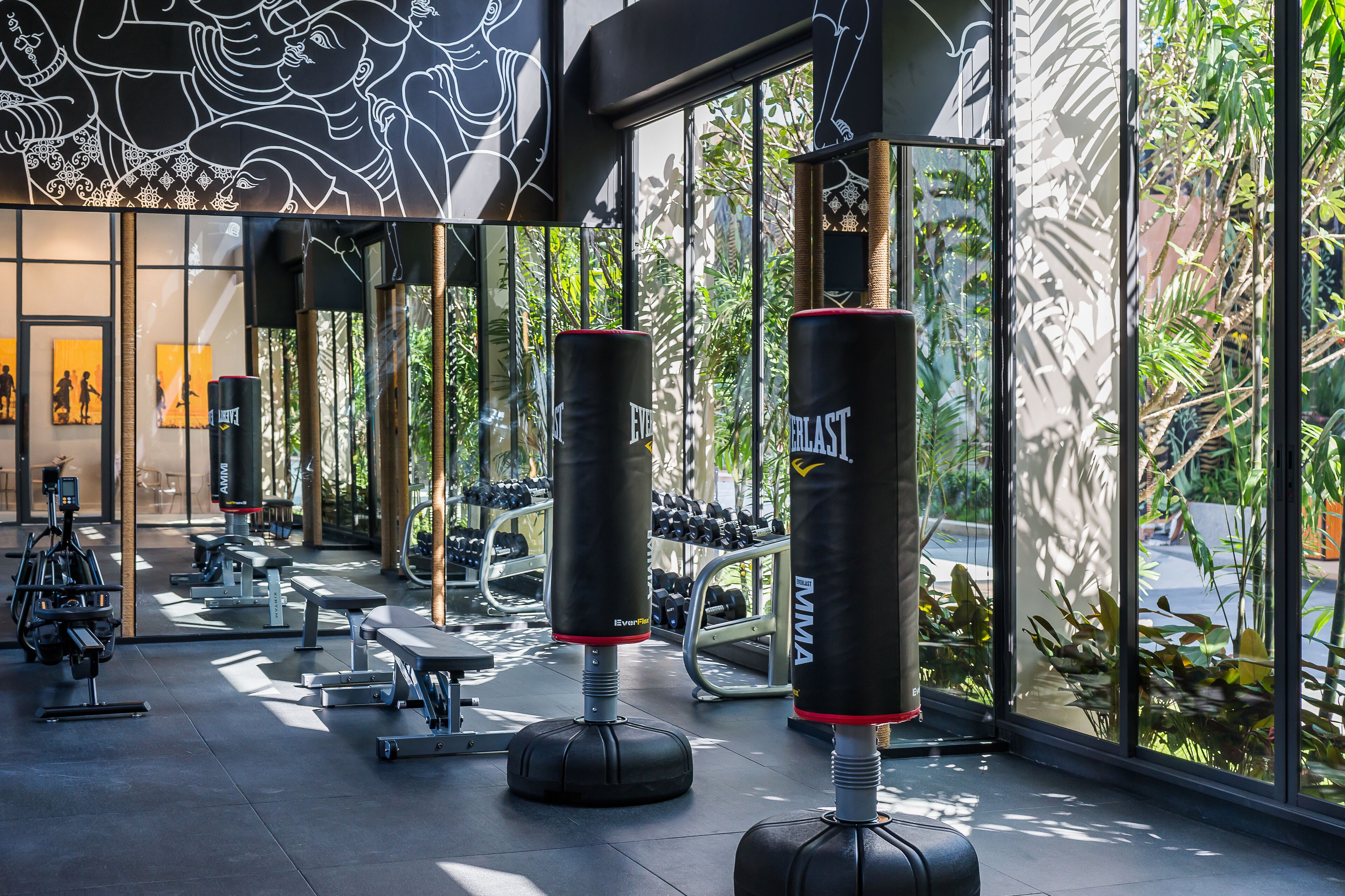 A gym with punching bags, weight benches, and exercise equipment.