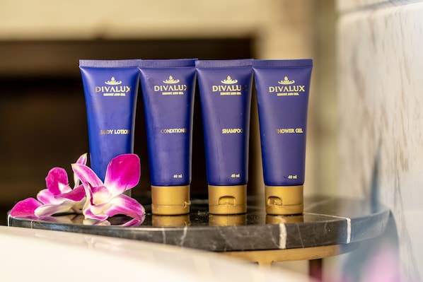 Four blue tubes of Divalux body care products on a marble surface with a purple orchid. - Divalux Resort & Spa Bangkok, Suvarnabhumi Airport (Bang Sao Thong)