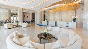 A spacious lobby with a curved seating area, a reception desk, and a modern chandelier. - Divalux Resort & Spa Bangkok, Suvarnabhumi Airport (Bang Sao Thong)
