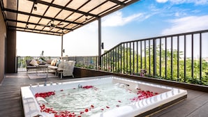 A rooftop terrace with a hot tub surrounded by rose petals, a seating area with a table, and a view of greenery. - Divalux Resort & Spa Bangkok, Suvarnabhumi Airport (Bang Sao Thong)