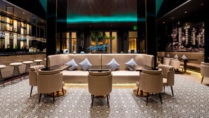 A modern bar area with a sofa and chairs, a patterned floor, and a bar counter with bottles and glasses. - Divalux Resort & Spa Bangkok, Suvarnabhumi Airport (Bang Sao Thong)