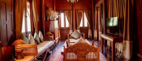 A traditional wooden room with a bed, a television, and a chandelier.