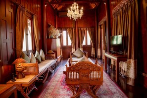 A traditional wooden room with a bed, a television, and a chandelier. - Divalux Resort & Spa Bangkok, Suvarnabhumi Airport (Bang Sao Thong)