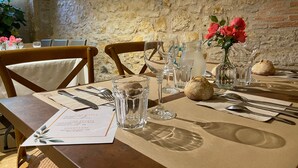 Ein gedeckter Restauranttisch mit Speisekarte, Weingläsern, einer Karaffe und einem Brotkorb.